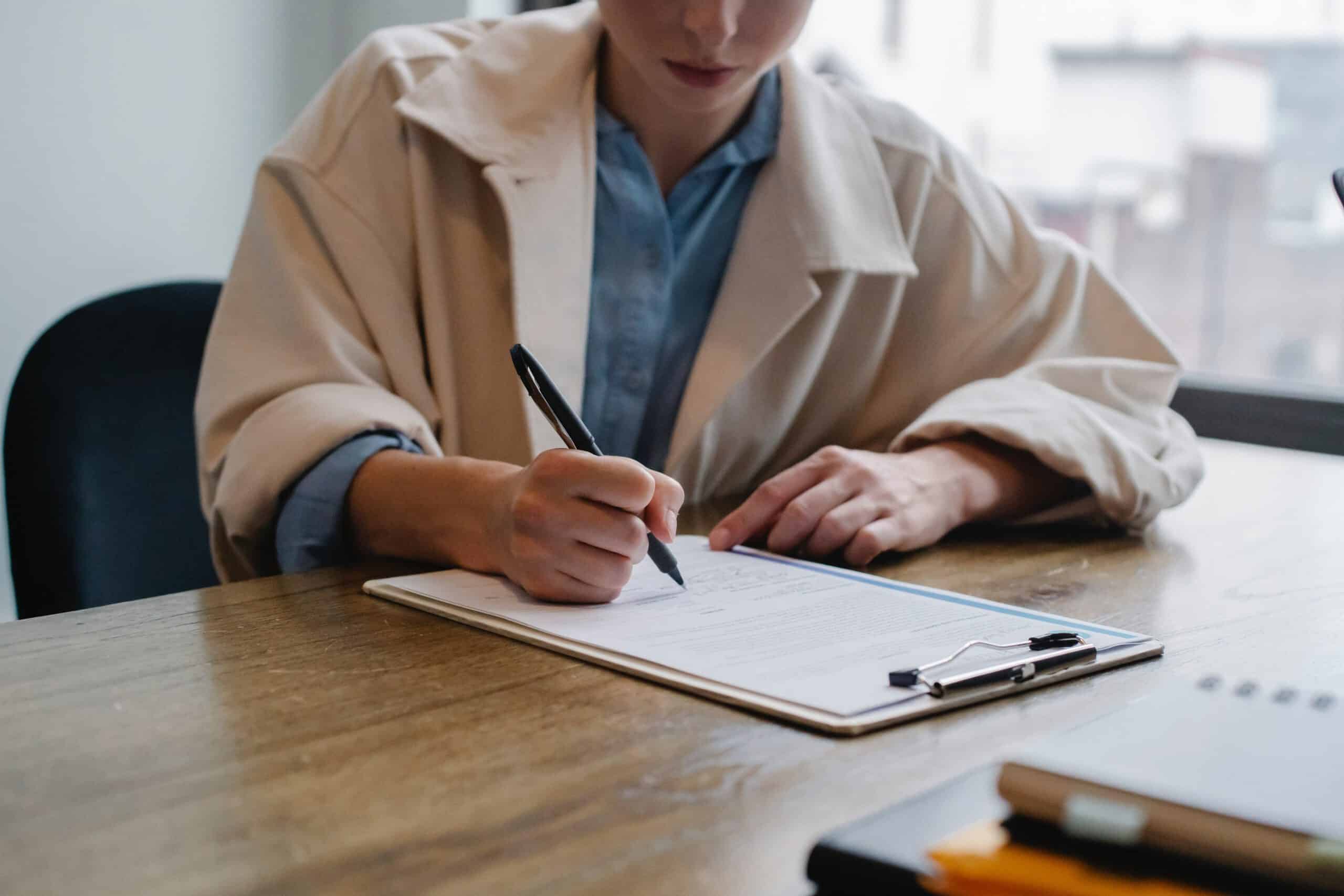 03_entretien_accueil_odfbdx Femme qui prend des notes pendant un entretien.